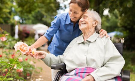 Betreuerin mit Seniorin im Garten